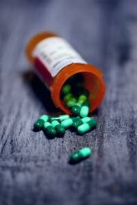 A pill bottle filled with green pills