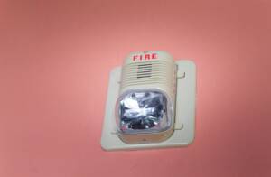 Fire alarm on a pink wall